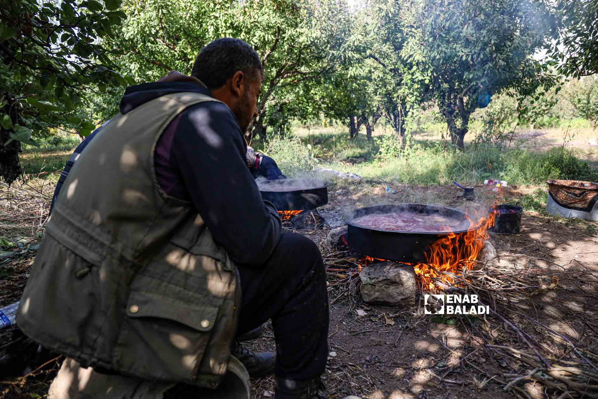 Farmers squeeze pomegranates and boil the juice in the traditional way to use later in the making of molasses in Basoutah village in Afrin region, Aleppo countryside - 18 October 2022 (Enab Baladi / Amir Kharboutli)
