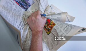 Enab Baladi’s illustration of a man tearing up an Arabic newspaper (Abdulmoeen Homs)