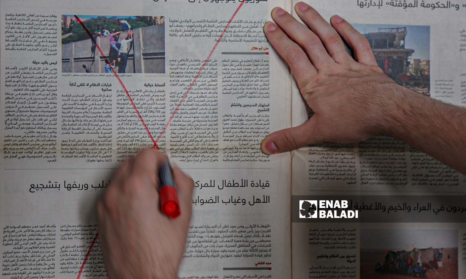 Enab Baladi’s illustration of a man drawing an X sign on an Arabic newspaper (Abdulmoeen Homs)