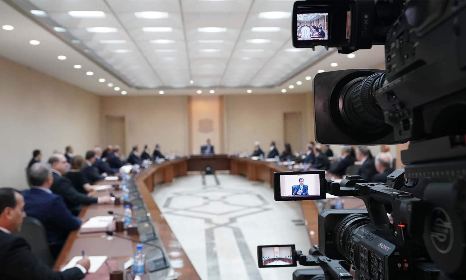 Head of the Syrian regime, Bashar al-Assad, appears in a camera lens while chairing the meeting of the new cabinet after it was sworn in - 14 August 2021 (Facebook/Presidency page)
