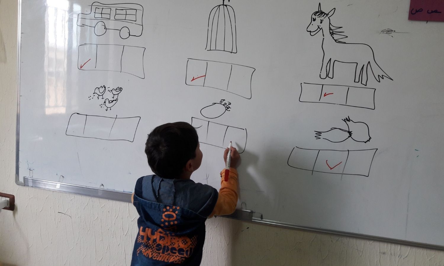 A child writes on the board at a school in Marj al-Bekaa, Lebanon (Gharsa Education Center)