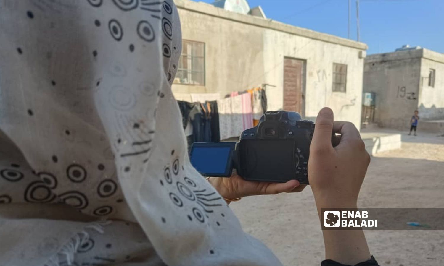 A Syrian journalist during her work in the Mashhad Rohin camps in Idlib - 12 December 2022 (Enab Baladi/Huda al-Kulaib)