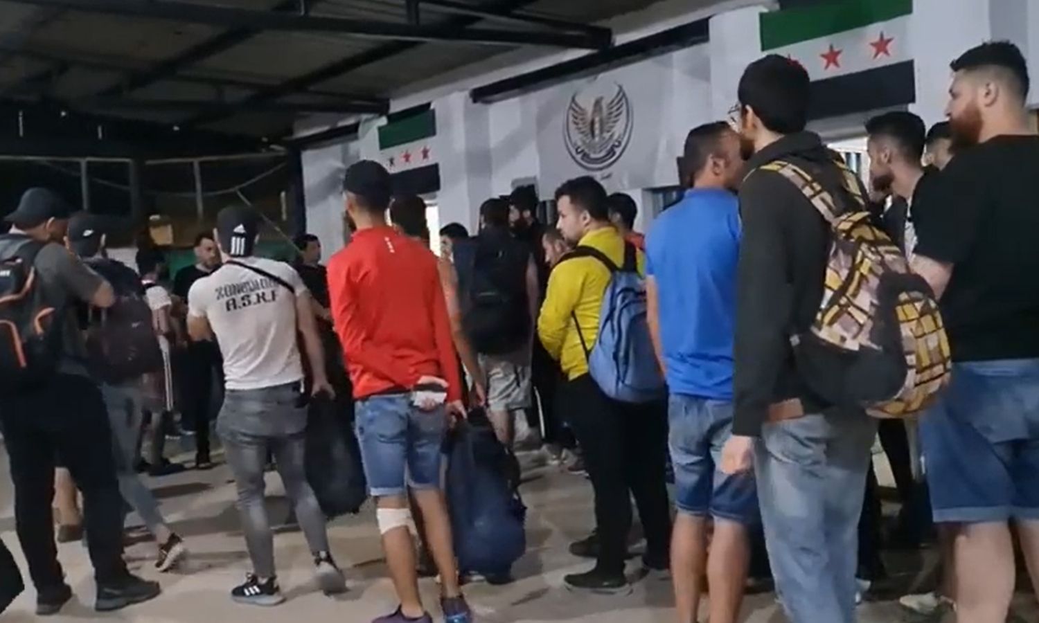 A group of Syrians at the Bab al-Salama border crossing after being deported from Turkey - 12 July 2022 (YouTube/Azaz Media Office)