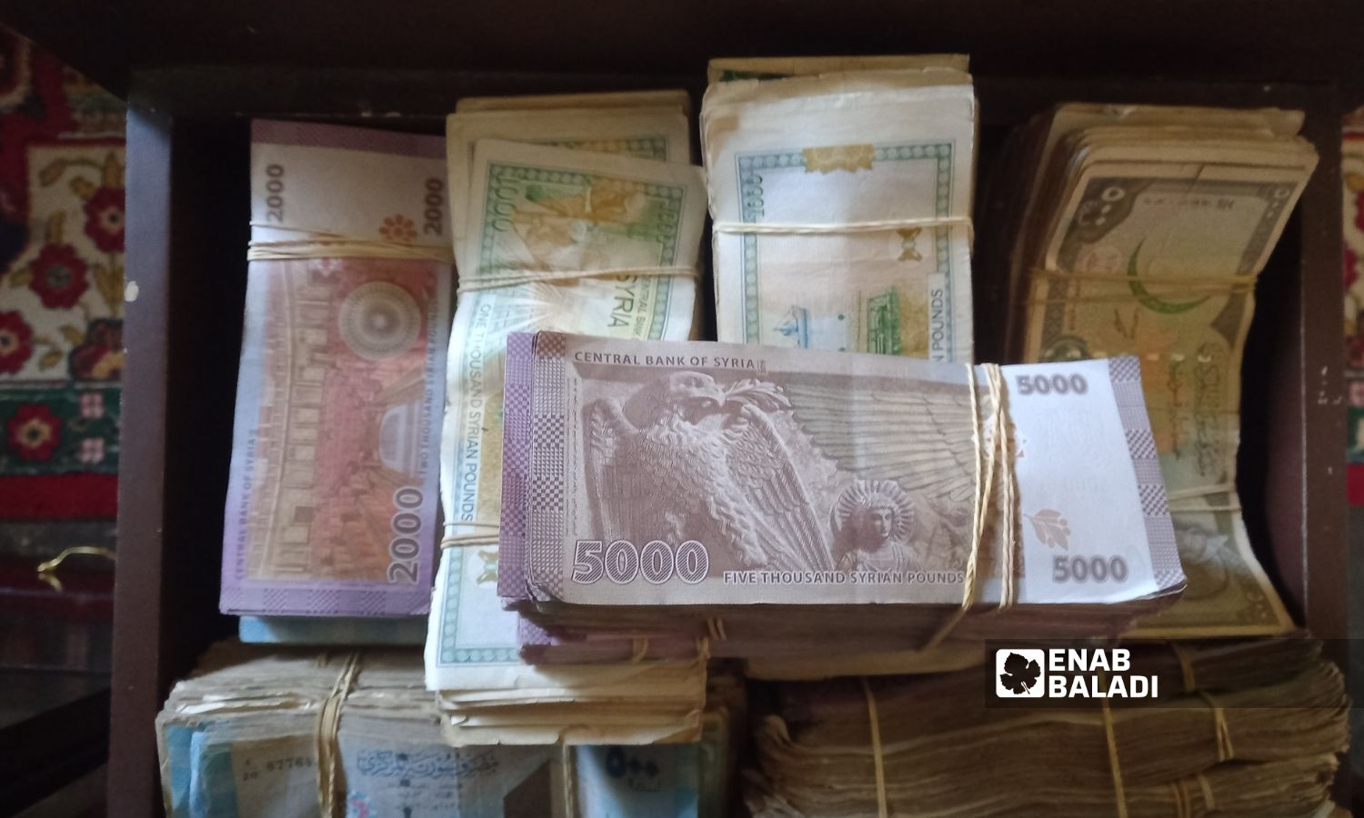 Stacks of Syrian pound notes (Enab Baladi)