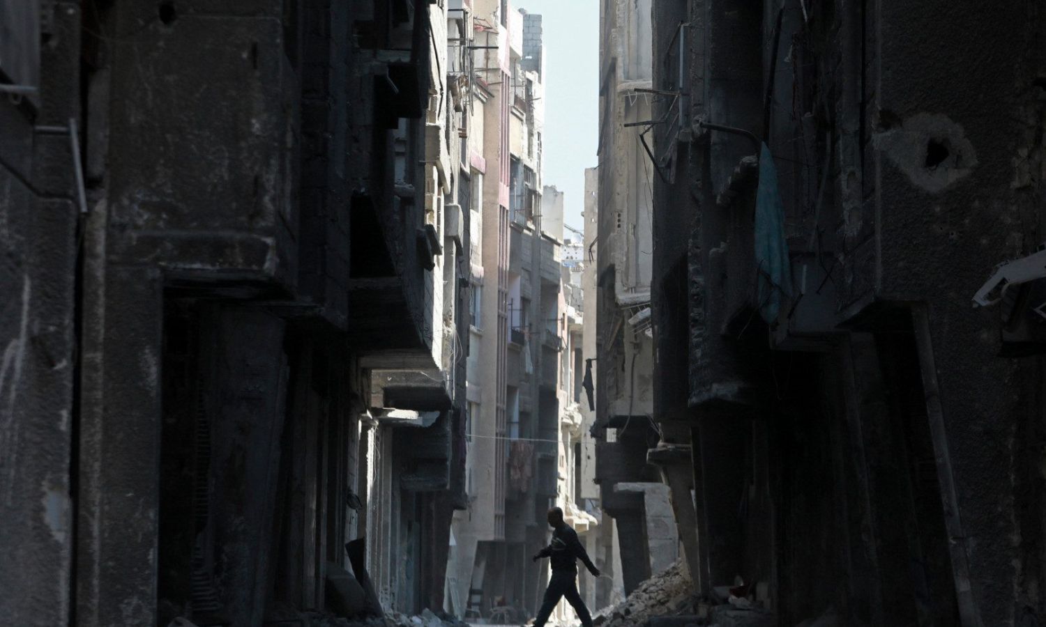 A man walking in the Yarmouk camp in the southern suburb of the Syrian capital, Damascus - 11 February 2022 (AFP)