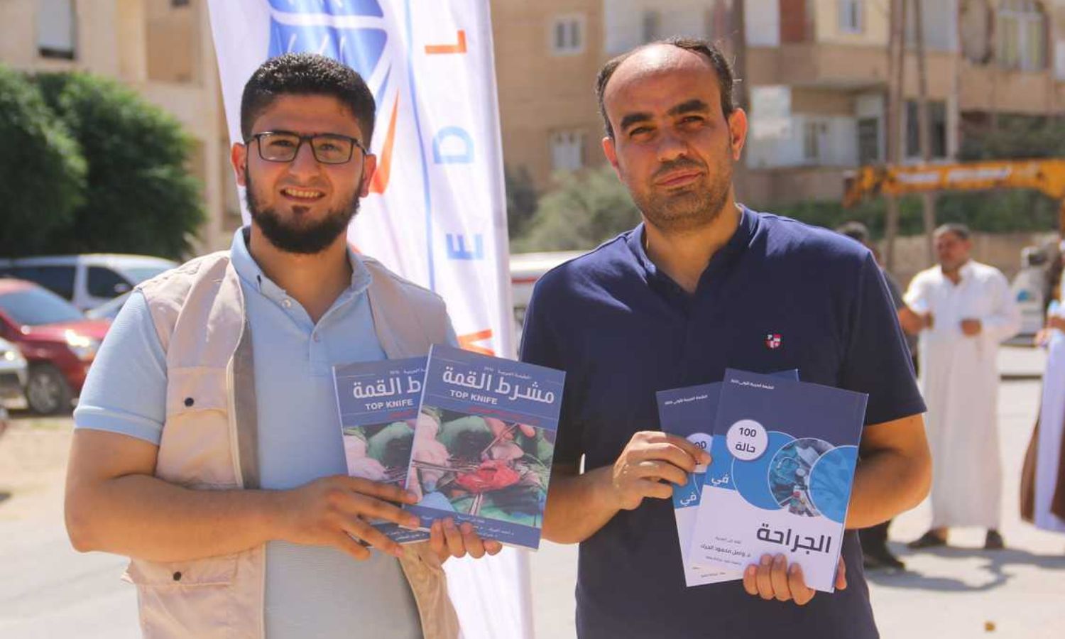 Doctor Wasel al-Jarak (right of the picture) in front of the Idlib Book Fair - 18 August 2022 (Wasel al-Jarak / Facebook)