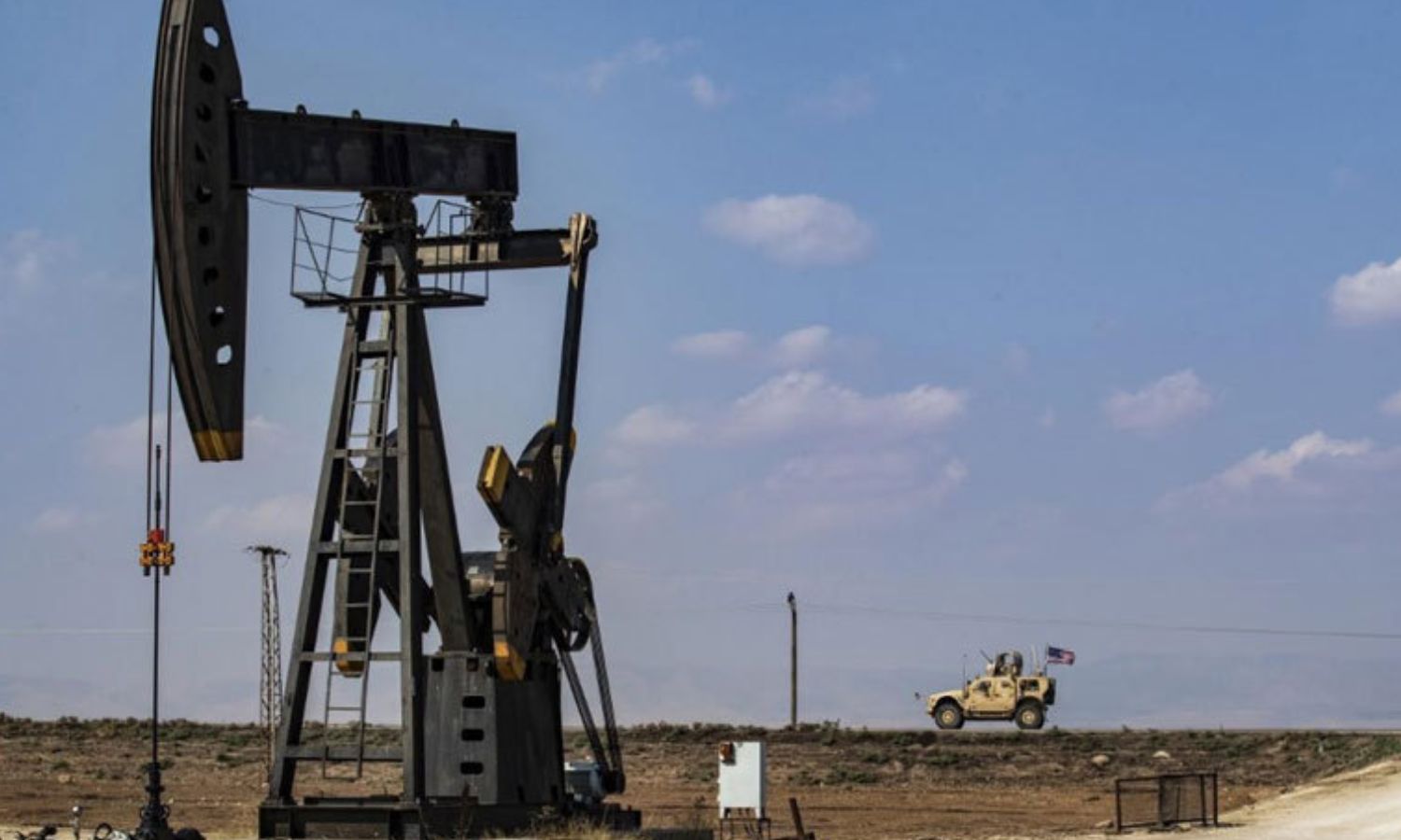 An American military vehicle passes near an oil rig in the countryside of the city of Qamishli, northeastern Syria - 26 October 2019 (AFP)