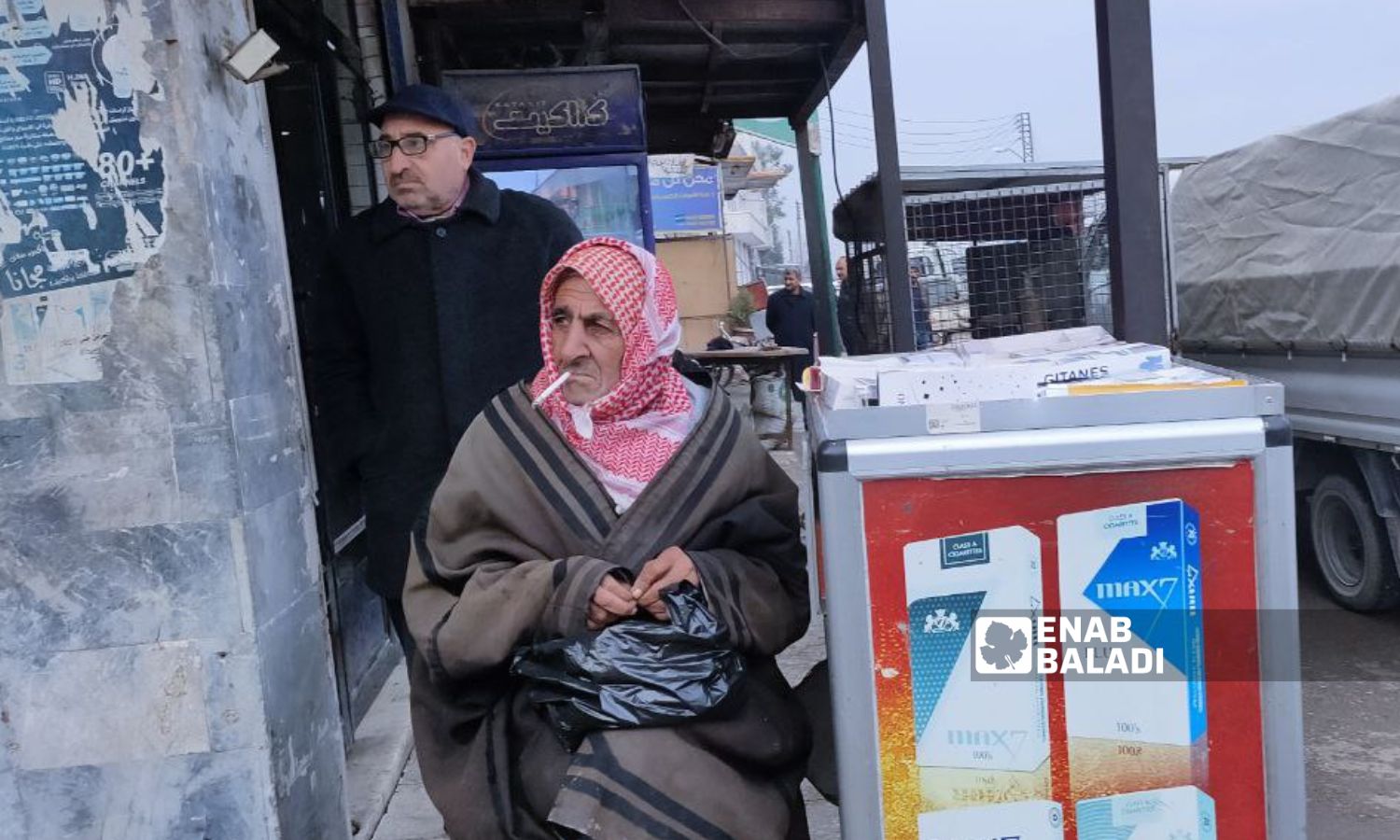 An old man selling cigarettes in the cold in a street in Qamishli - 24 December 2022 (Enab Baladi/Majd al-Salem )