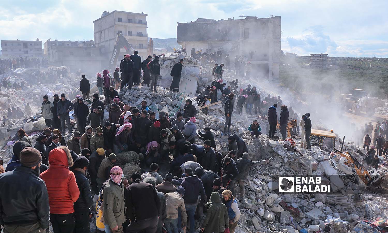 Rescue teams and volunteer residents search for survivors among the rubble of collapsed buildings in the village of Basnia, near Harem town on the Syrian-Turkish border, following the massive earthquake that struck Turkey and northwestern Syria - February 7, 2023 (Enab Baladi/Mohammad Nasan Dabel)