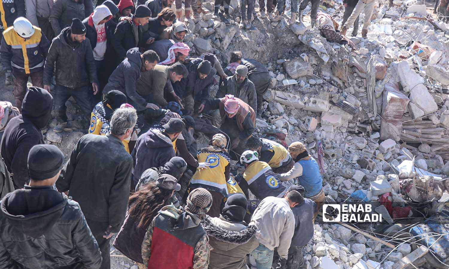 Syria Civil Defense teams and volunteer residents continue rescue operations for victims and survivors under the rubble of collapsed buildings following an earthquake that struck areas in northwestern Syria, in the village of Basniya, near the border town of Harem - February 7, 2023 (Enab Baladi/Mohammad Nasan Dabel)