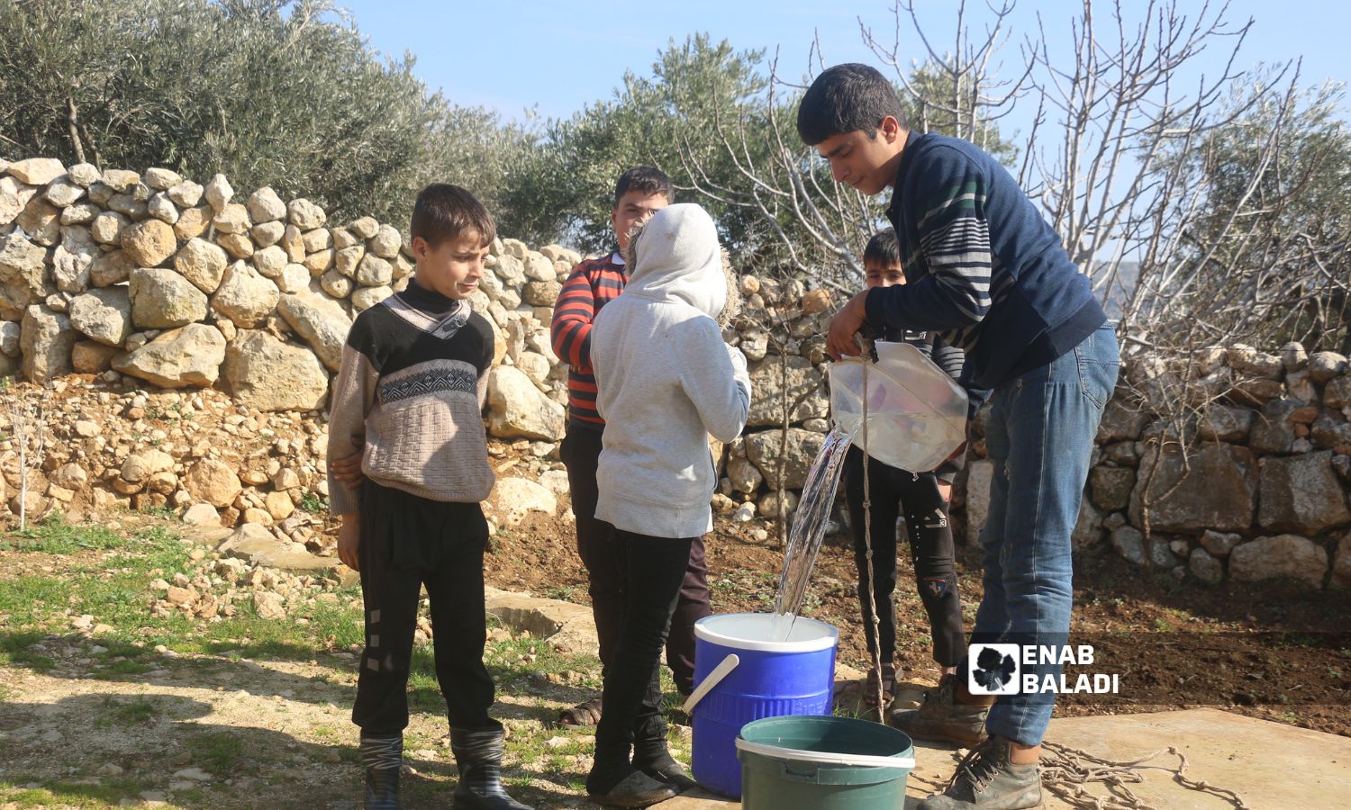 Children extracting water from a Roman well in the village of Sardin in the northern countryside of Idlib - January 22, 2023