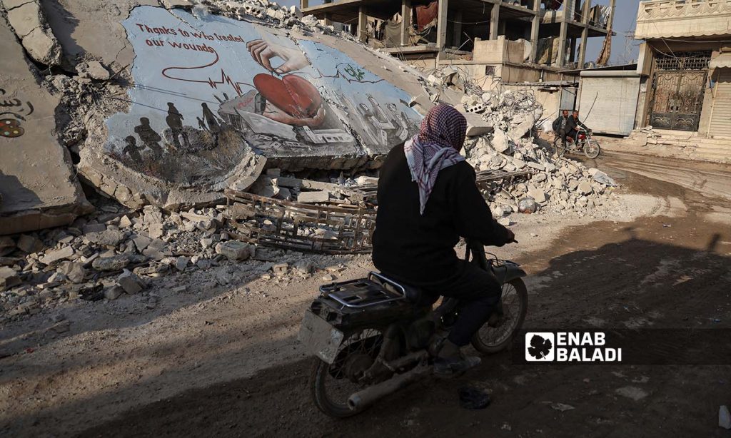 Graffiti on the rubble of buildings destroyed by the earthquake that struck Jindires town in Aleppo countryside - February 24, 2023 (Enab Baladi/Amir Kharboutli)