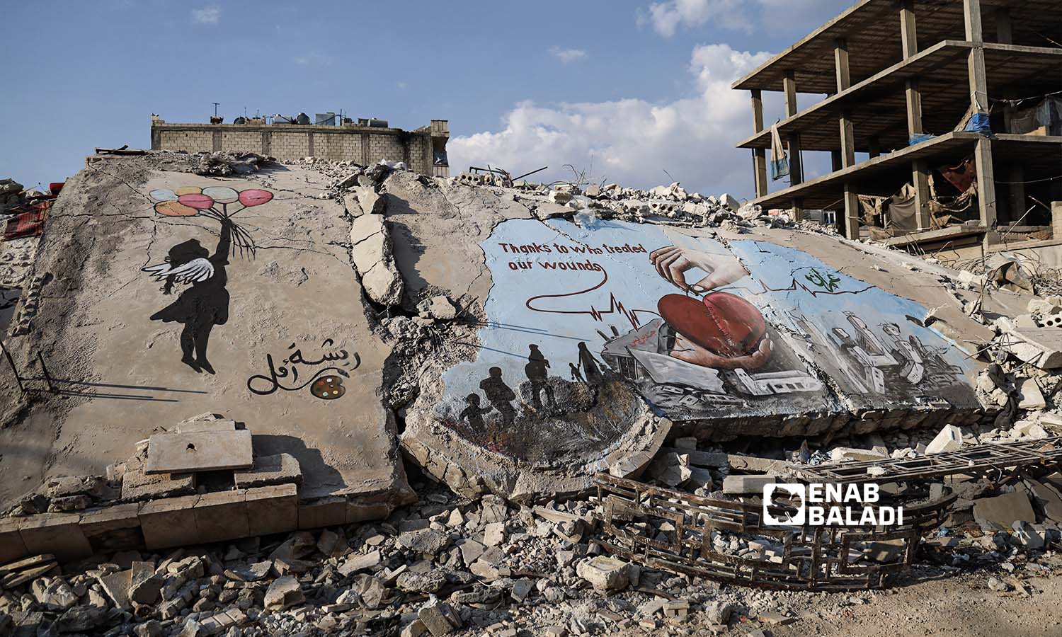 Graffiti on the rubble of buildings destroyed by the earthquake that struck Jindires town in Aleppo countryside - February 24, 2023 (Enab Baladi/Amir Kharboutli)
