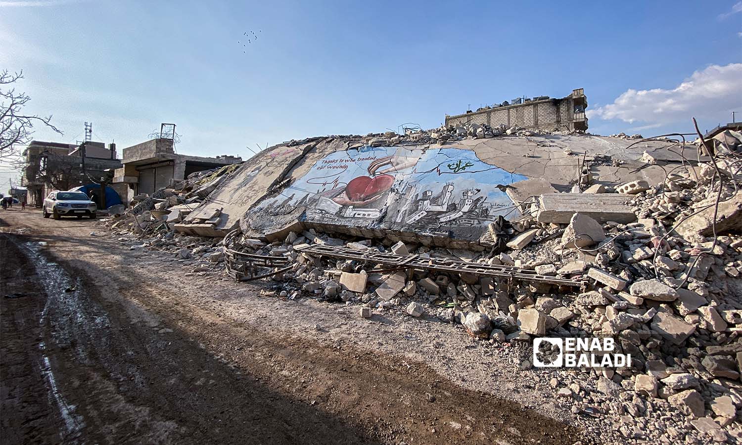 Graffiti on the rubble of buildings destroyed by the earthquake that struck Jindires town in Aleppo countryside - February 24, 2023 (Enab Baladi/Amir Kharboutli)
