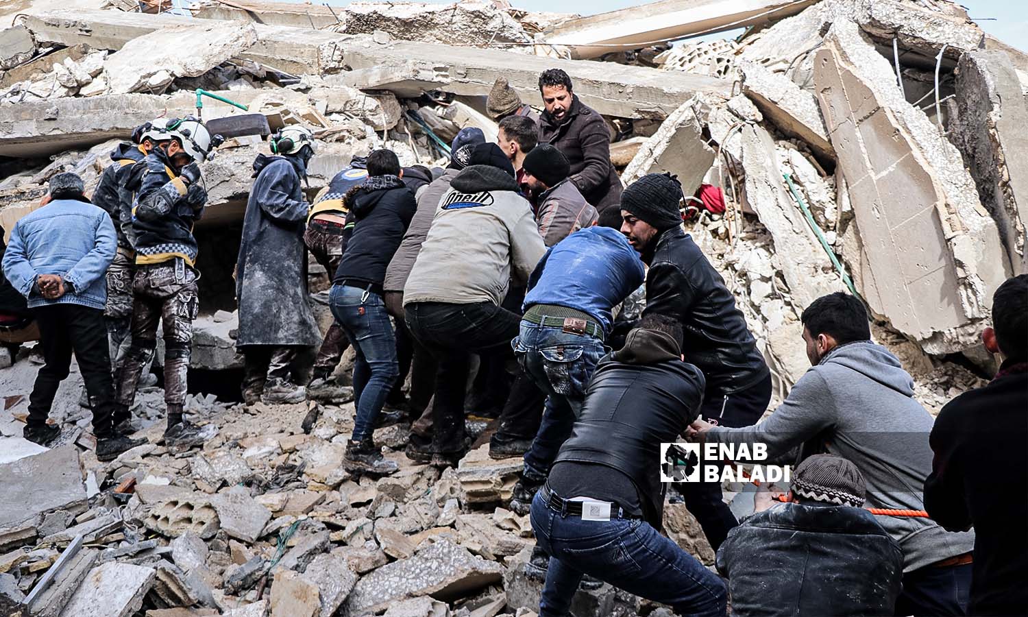 Volunteers try to rescue and lift survivors from under the rubble in Azmarin village following the earthquake that struck the northwestern Syrian region - February 7, 2023 (Enab Baladi/Mohammad Nasan Dabel)
