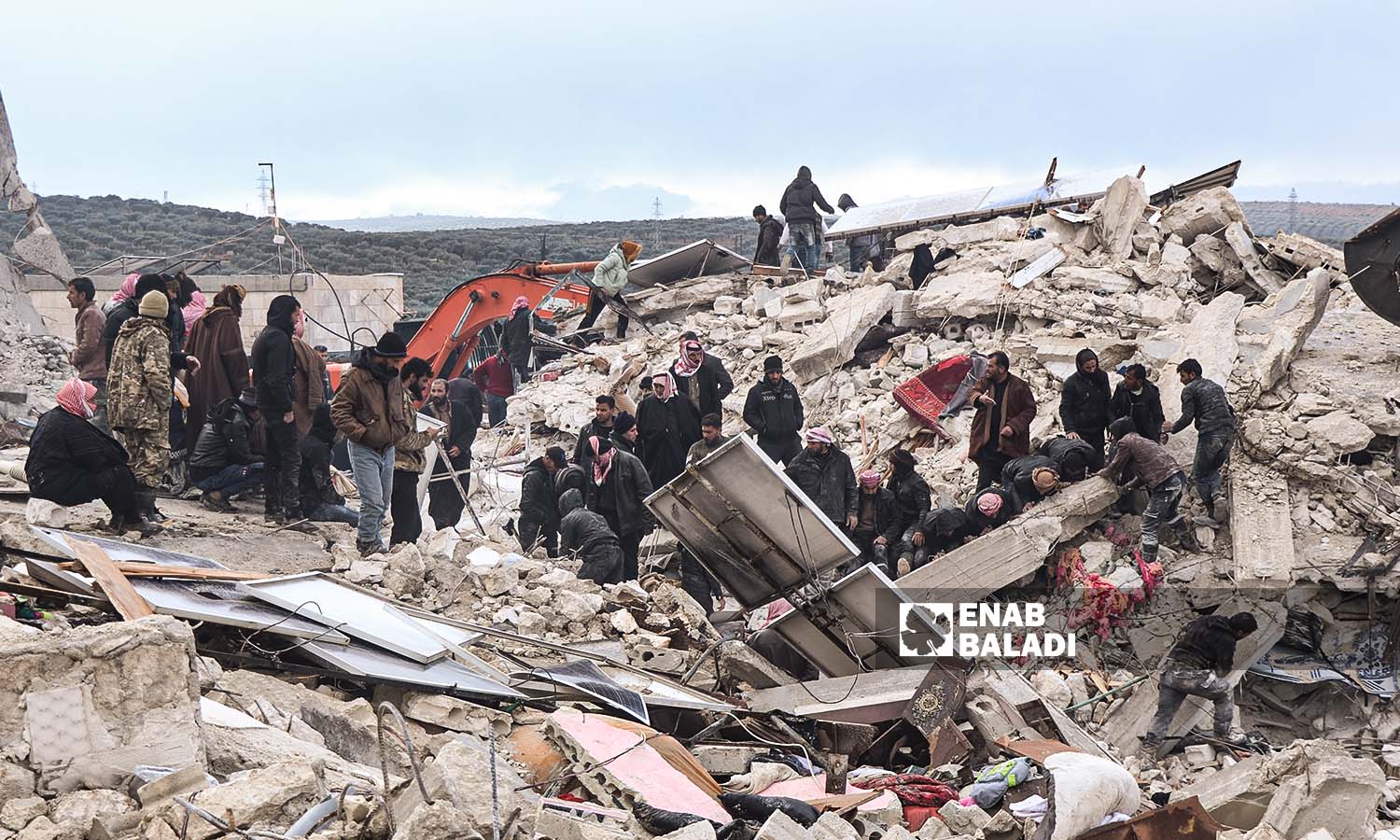 Volunteers try to rescue and lift victims out of the rubble in the Harem area following the devastating earthquake that hit northwestern Syria - 6 February 2023 (Enab Baladi/Mohammad Nasan Dabel)
