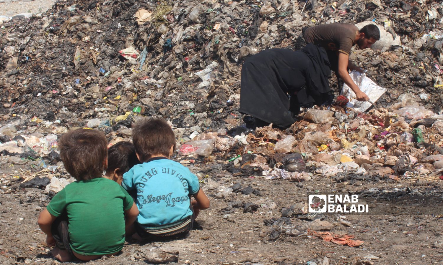 A family collecting scraps from a garbage dump near the town of Qah on the Syrian-Turkish border - August 1, 2020 (Enab Baladi)