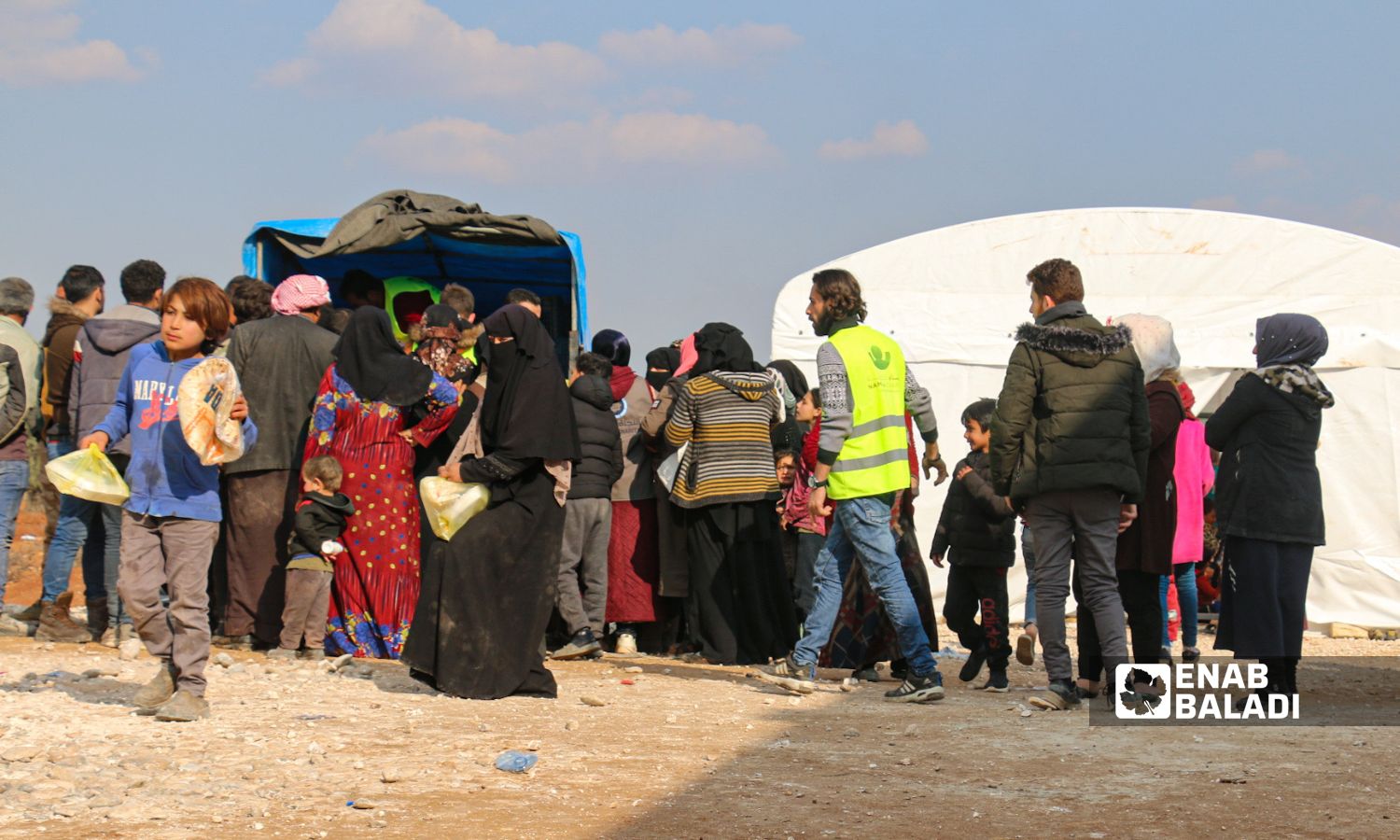 Distributing aid and food baskets to people in the town of Jindires in the northern countryside of Aleppo city who were affected by the earthquake that struck southern Turkey and northwestern Syria - February 13, 2023 (Enab Baladi/Dayan Junpaz)