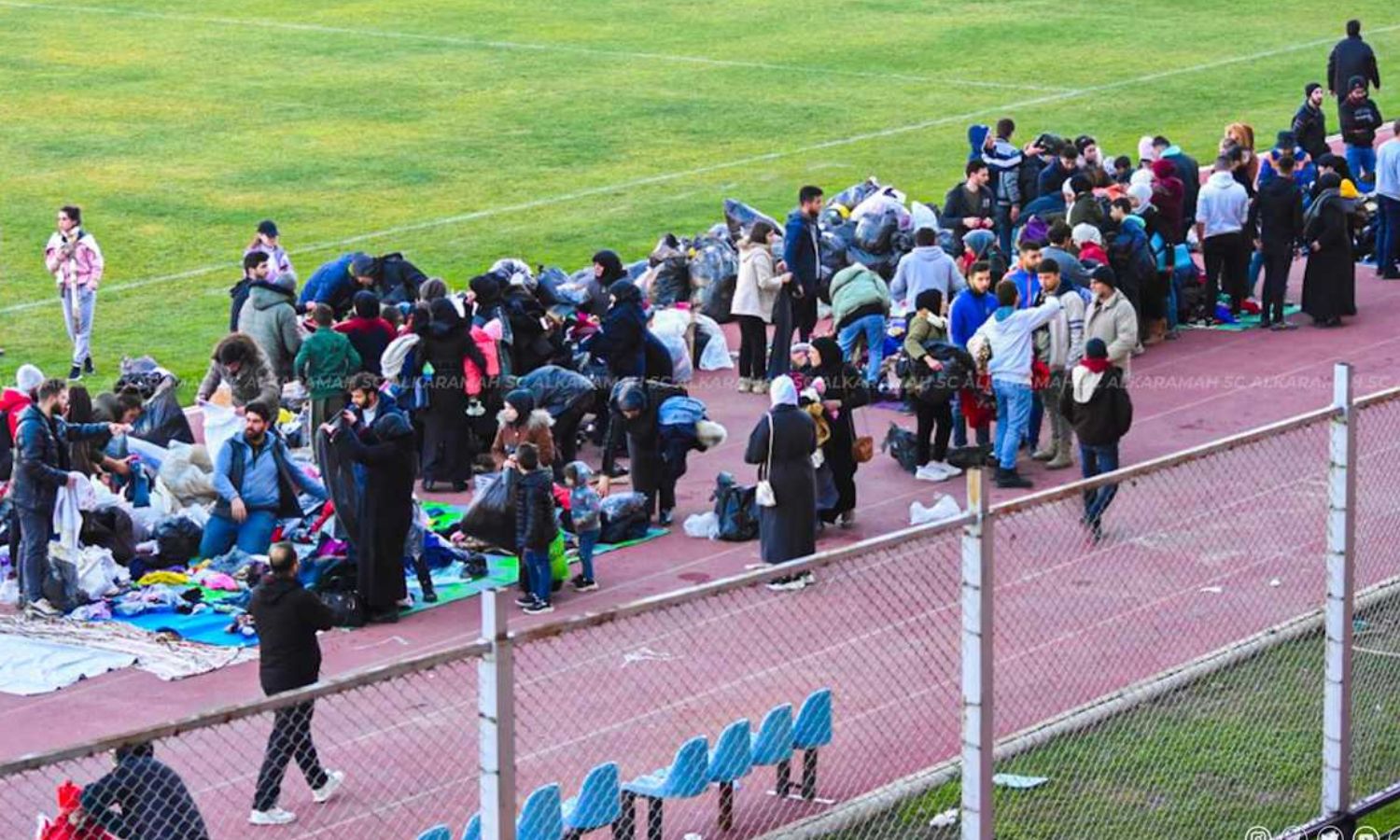 The distribution of aid to the affected people who sought refuge in the al-Hamdaniya football stadium in Aleppo following an earthquake that struck the region - February 9, 2023 (Al-Karamah SC Football Club)
