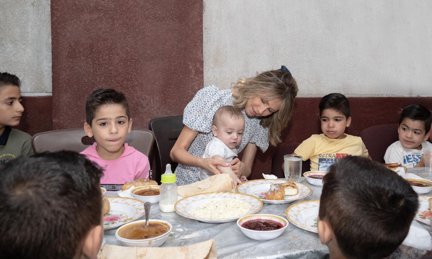 Asma al-Assad, wife of the head of the Syrian regime, meets children in an orphanage in Aleppo - July 2022 (Syrian Presidency/Facebook)