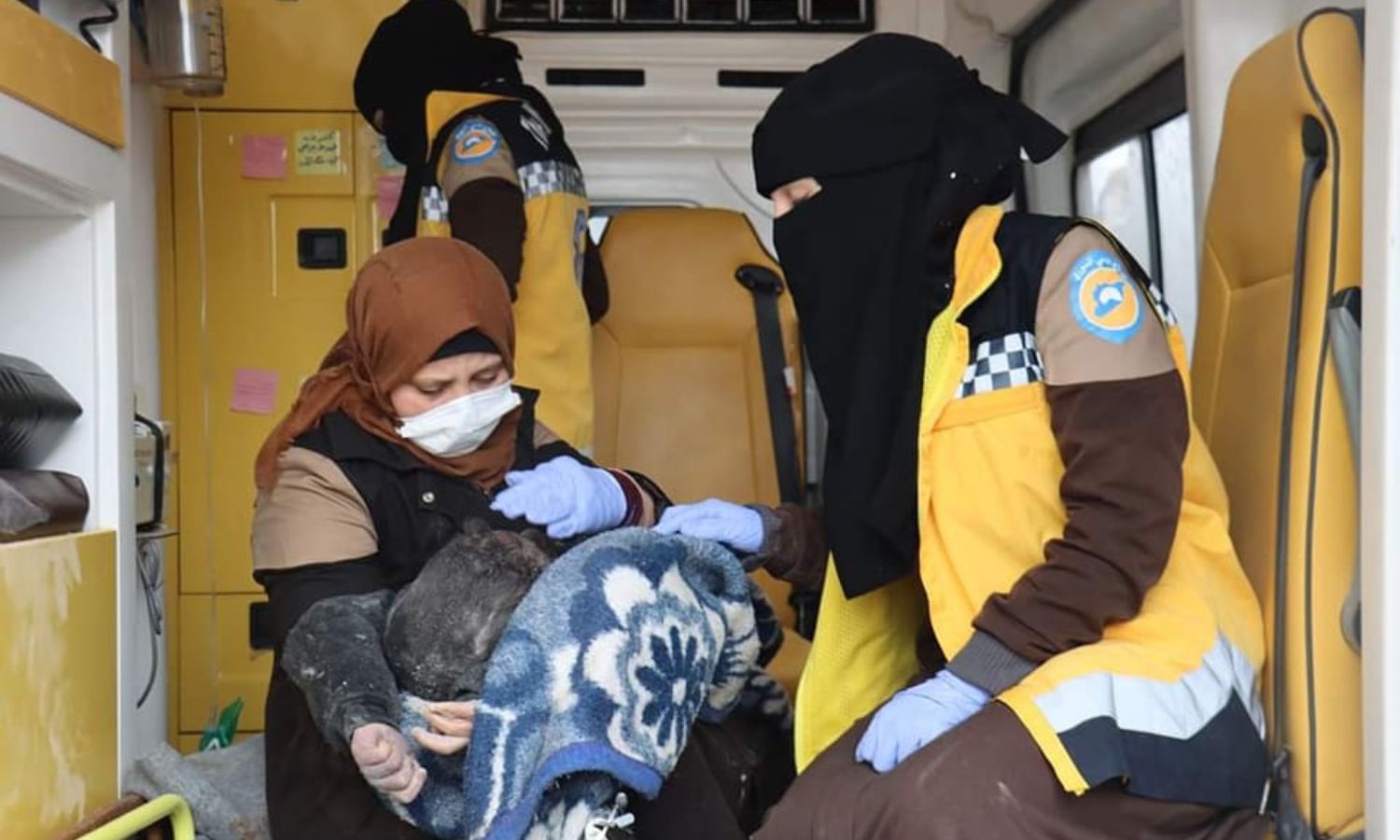 Volunteers in the Syria Civil Defense with a child who was rescued from under the rubble in the village of Millis in the northern countryside of Idlib, following an earthquake that struck northwestern Syria - February 6, 2023 (Facebook/Syria Civil Defense)