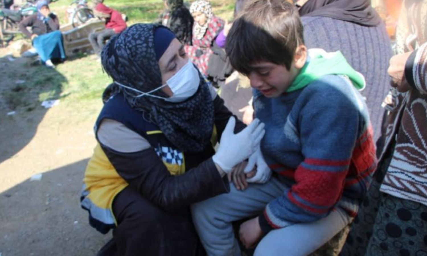 A White Helmets volunteer consoles a child boy who was waiting for his friend’s body to be recovered from under the rubble in the village of Azmarin, northwestern Syria (The Syria Civil Defense)