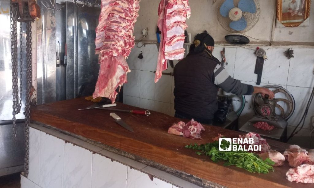 A butcher chops meat in his shop in Daraa - December 28, 2022 (Enab Baladi/Halim Muhammad)