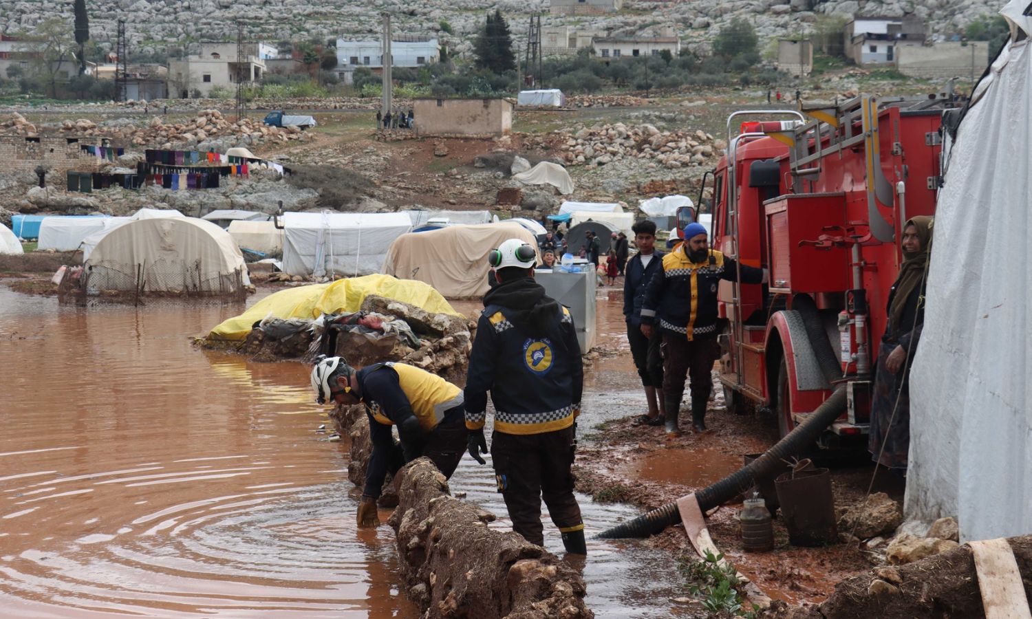 Volunteers of the Syria Civil Defense digging small canals to bring water outside the camps for the displaced in northern Syria - March 19, 2023 (Facebook/Syria Civil Defense)