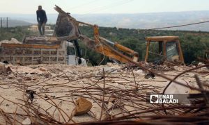 Construction workers collect iron bars from quake-damaged buildings in Salqin city in Idlib countryside - April 30, 2023 (Enab Baladi/Iyad Abdul Jawad)
