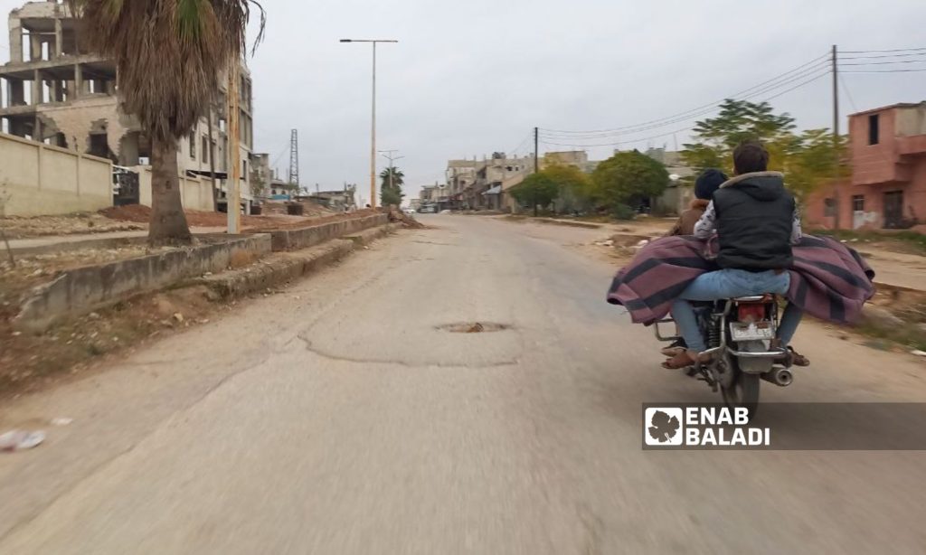 Two people on a motorbike in the city of al-Rastan in central Homs governorate - December 29, 2022 (Enab Baladi)