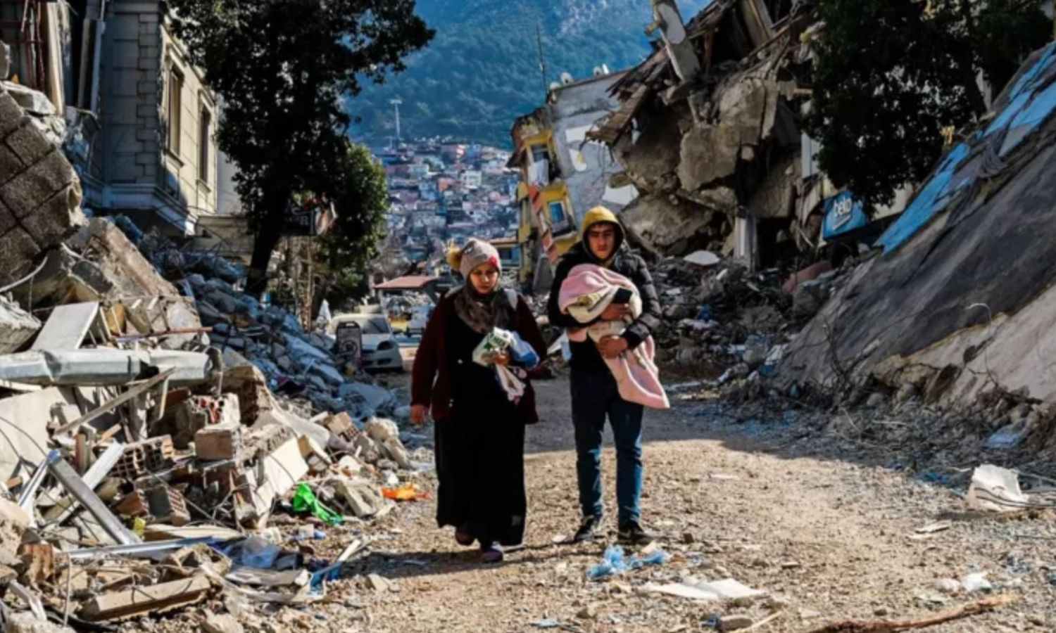A woman and a man walk through the earthquake ruins in Hatay state, southern Turkey - February 12, 2023 - (Getty Images)