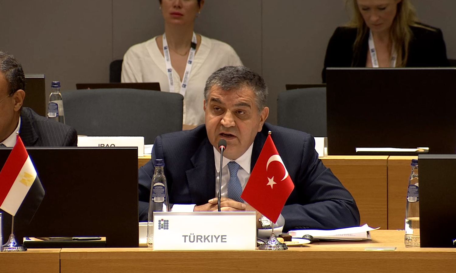 Turkish Ambassador to the EU, Faruk Kaymakci, giving a speech about Syrian refugees and the voluntary return project during his participation in the Brussels Conference - June 15, 2023 (EU - Screenshot)
