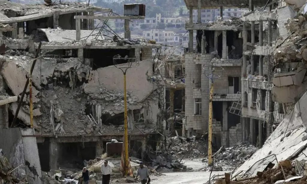 Residents walking among the rubble and damaged power lines in the tourist town of Zabadani in Damascus suburbs - May 2017 (AP)