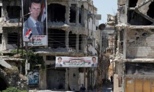 Two banners calling for Bashar al-Assad’s election were hung on the destroyed buildings in central Homs city (Reuters)
