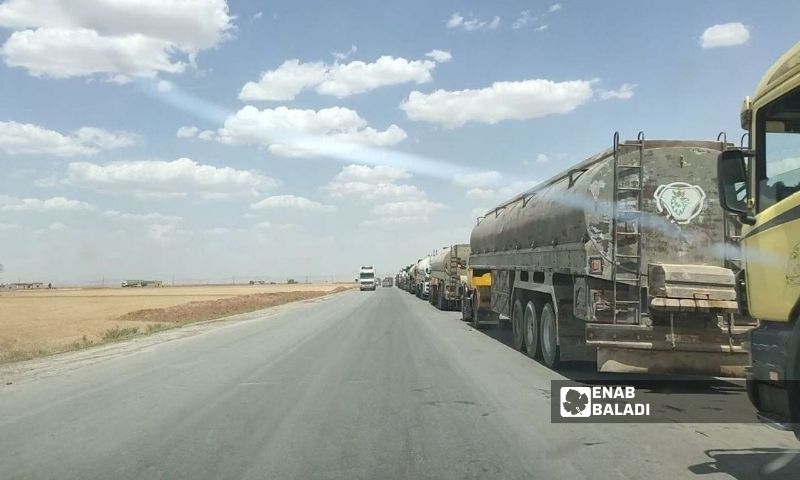 Dozens of fuel tanker trucks of the Qaterji Company queuing on the international road west of Qamishli to enter the Rumeylan and al-Shaddadi oil fields - May 28, 2022 (Enab Baladi/Majd al-Salem)