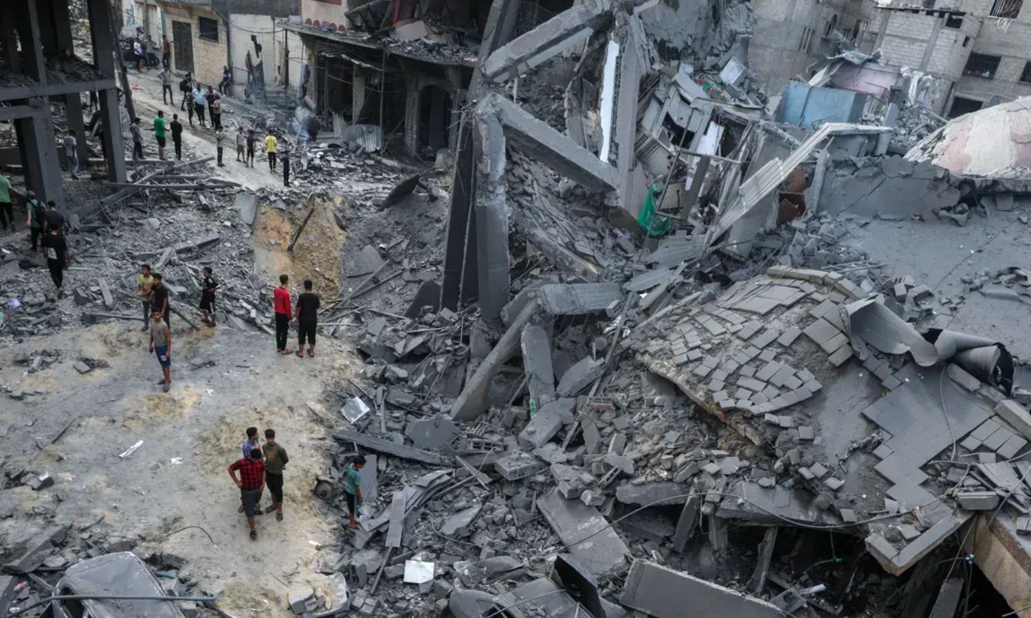 Palestinians walking through the rubble of an area destroyed by Israeli bombing in Gaza city - October 9, 2023 (EPA)
