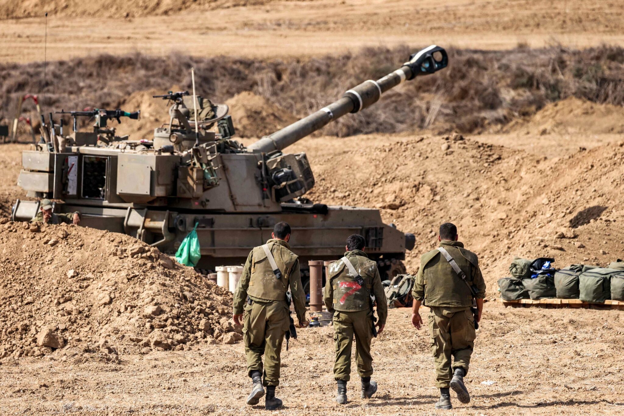 Israeli army soldiers near a self-propelled howitzer (fight tank), near the border with Gaza - October 12, 2023 (AFP)