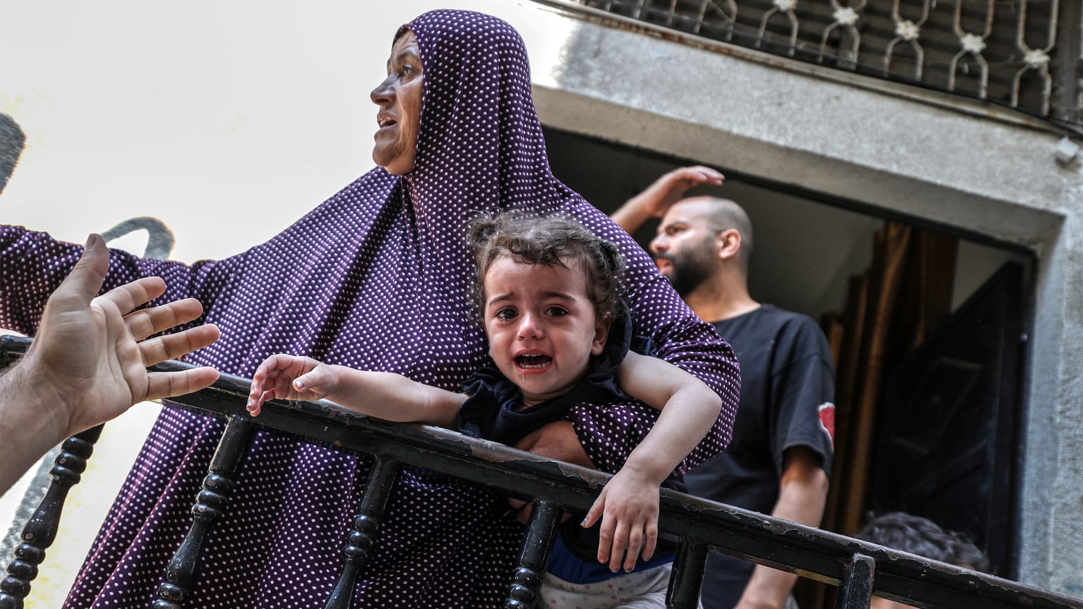 A woman carries a terrified child due to the impact of the Israeli bombing on the Gaza Strip - October 15, 2023 (Anadolu Agency)