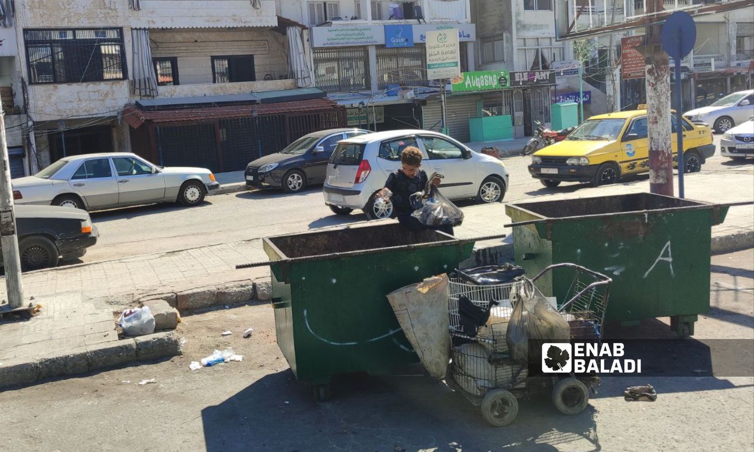A child makes a living by selling garbage waste near the Sbiro parking lot in the coastal Latakia city - September 2023 (Enab Baladi/Linda Ali)