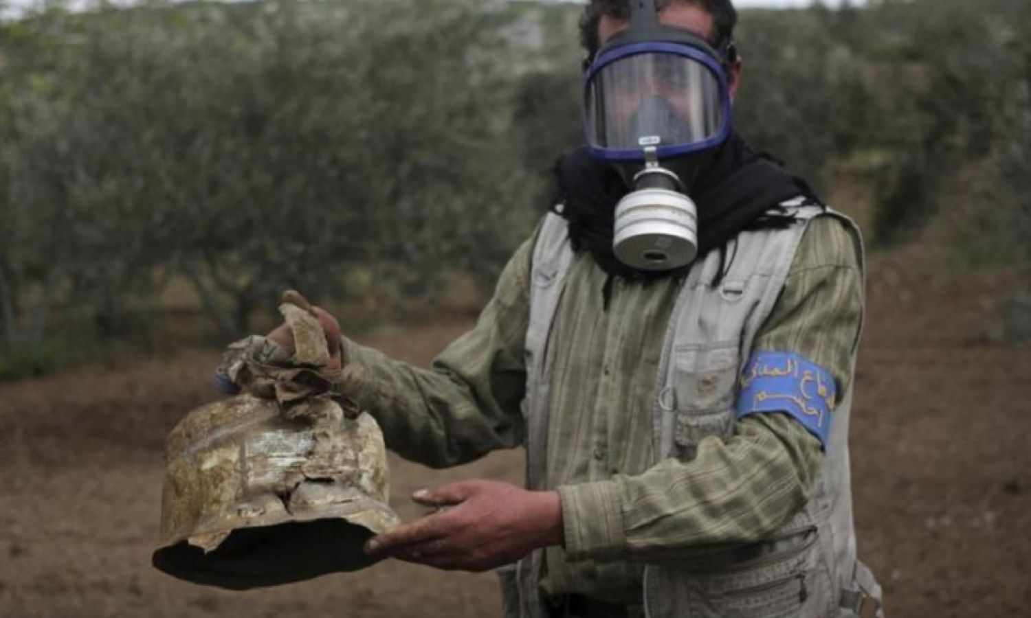 A civil defense member carries a damaged canister in the village of Iblin after an attack targeting the villages of Kansafra, Iblin, and Joseph in the Idlib countryside with chlorine gas, May 3, 2015 (Reuters)