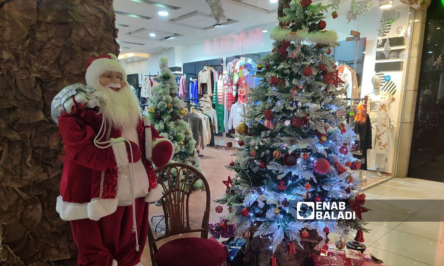 A Christmas tree in front of a clothing store at the Orange Mall in Latakia - December 21, 2023 (Enab Baladi/Linda Ali)