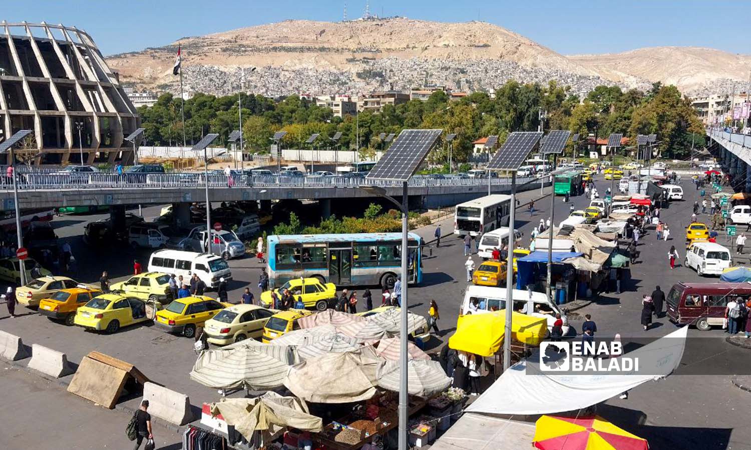 Buses and taxis under the President’s Bridge (Jisr al-Rais) in Damascus - October 26, 2023 (Enab Baladi/Sarah al-Ahmad)
