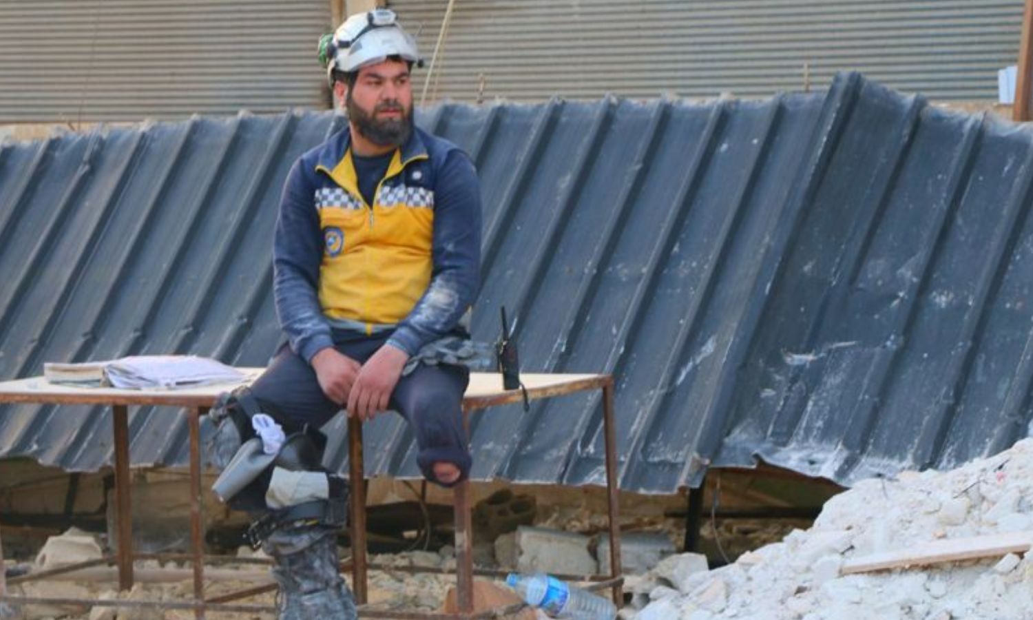 Volunteer for the Syria Civil Defense Hassan al-Talfah sits, with his prosthetic limb next to him, to rest after rescuing people trapped under the rubble following the earthquake in the countryside of Idlib - February 12, 2023 (Hatim al-Khader/Facebook)