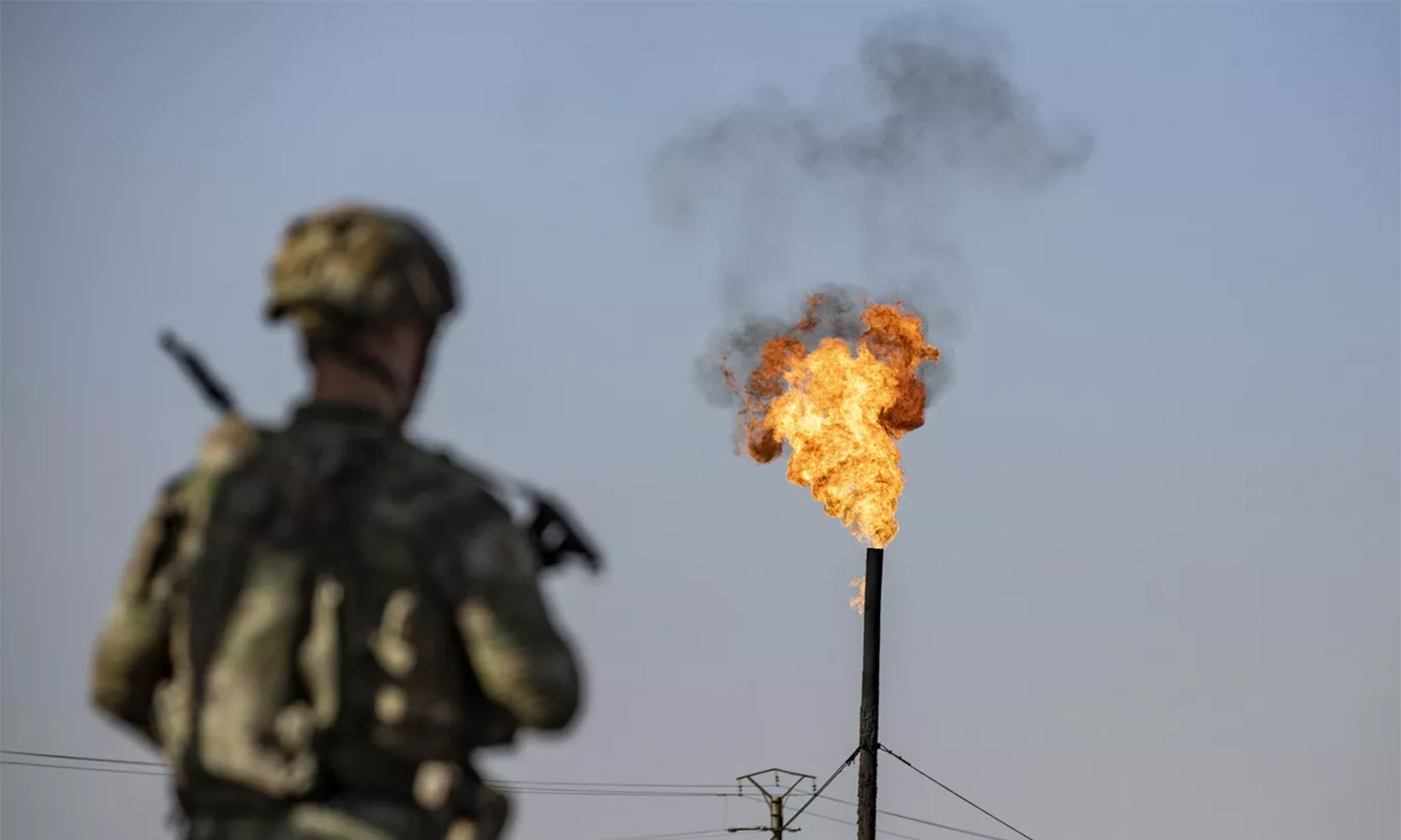 A US soldier opposite an oil field in northeast Syria, 2023 (AFP/Delil Souleiman)