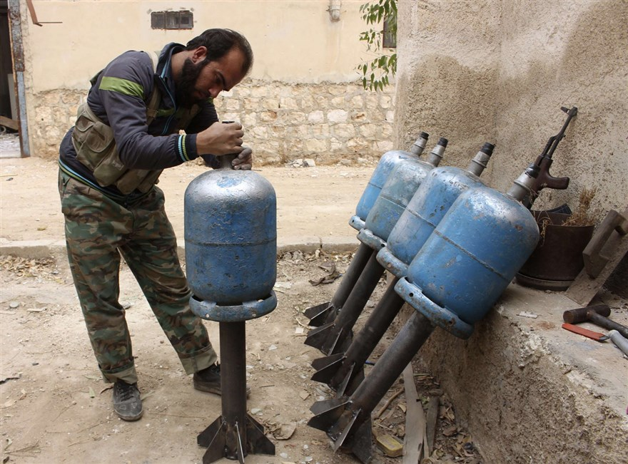 A fighter from Liwa al-Tawhid preparing to launch homemade projectiles at Brigade 80 in Aleppo - November 11, 2013 (Reuters)