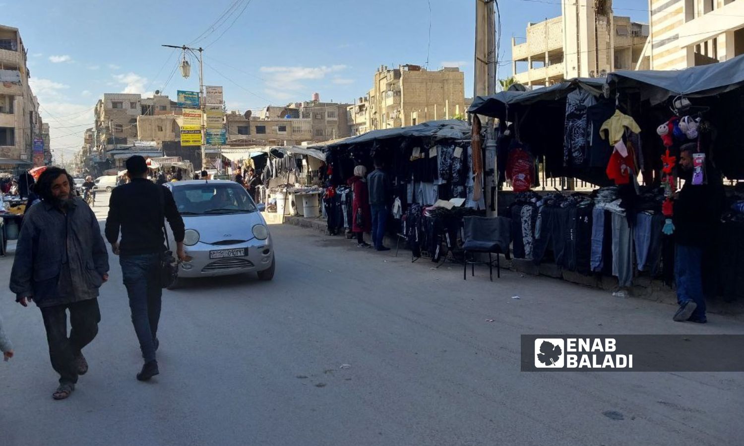 Clothing stalls in the al-Jalaa Street in front of the Great Mosque in Douma city, rural Damascus - January 22, 2024 (Enab Baladi/Sarah al-Ahmad)
