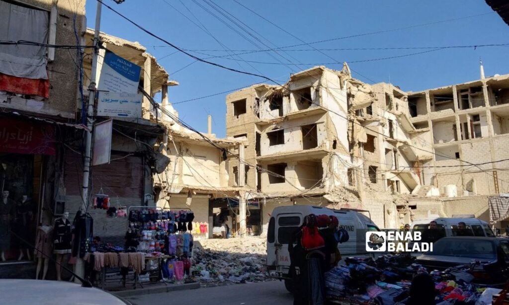 Shops and clothing stalls in the al-Jalaa Street in Douma city. The buildings were bombed by Syrian regime warplanes during opposition factions' control of the city - January 22, 2024 (Enab Baladi/Sarah al-Ahmad)