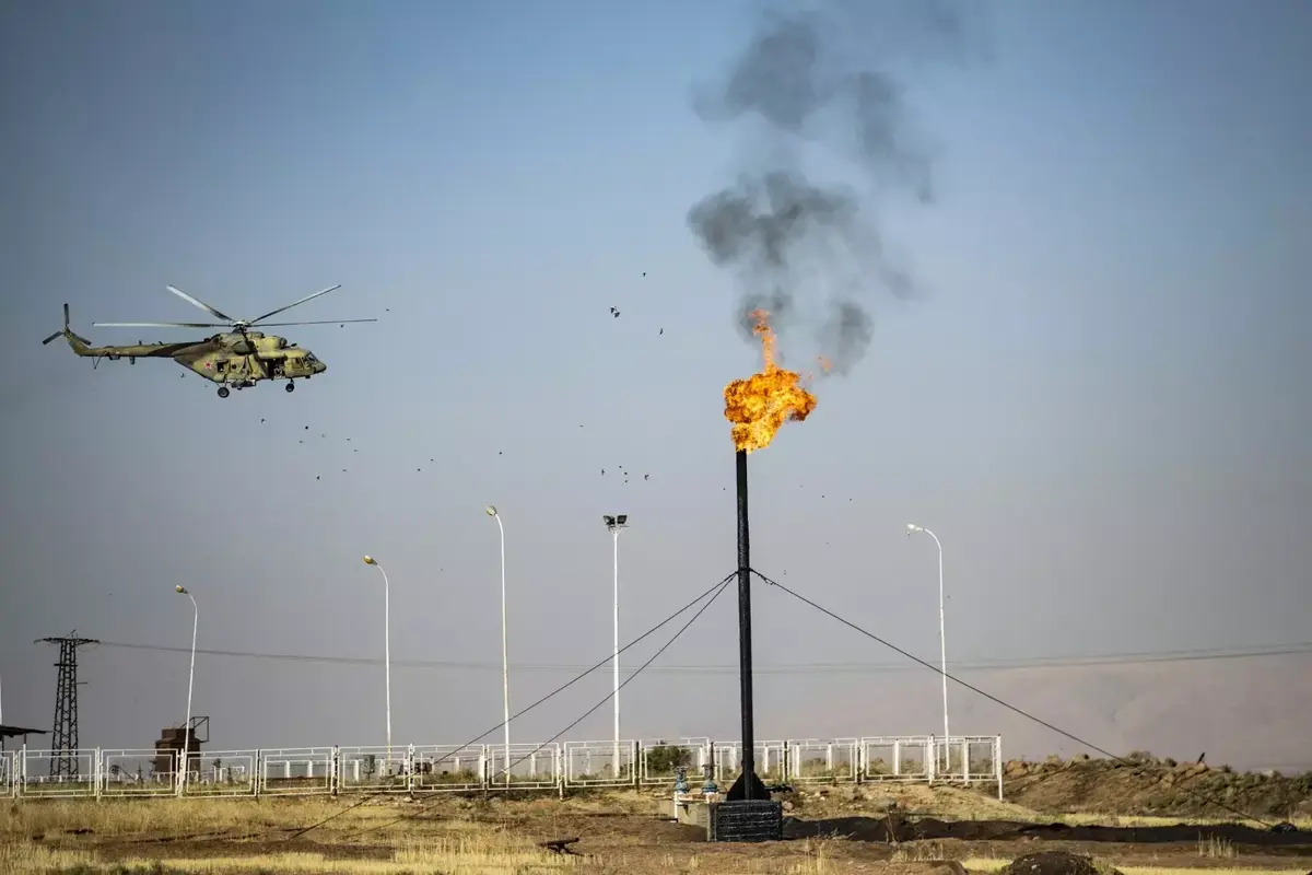 A Russian military helicopter flies over an oil field near the town of al-Qahtaniyah in the al-Hasakah province in northeast Syria - October 11, 2020 (AFP)