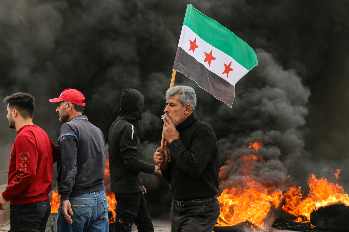 A man carries the flag of the Syrian revolution in the city of Azaz denouncing the attempt of Hayat Tahrir al-Sham to enter it - October 16, 2023 (Enab Baladi/Dayan Junpaz)