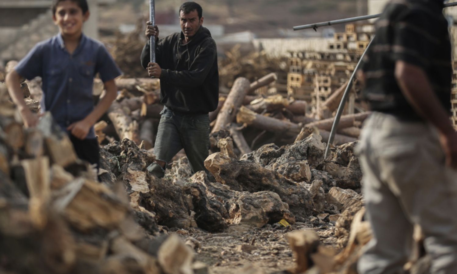 Syrian men cut pieces of wood to serve as a source of warmth during winter - November 3, 2020, Syria (PAX)